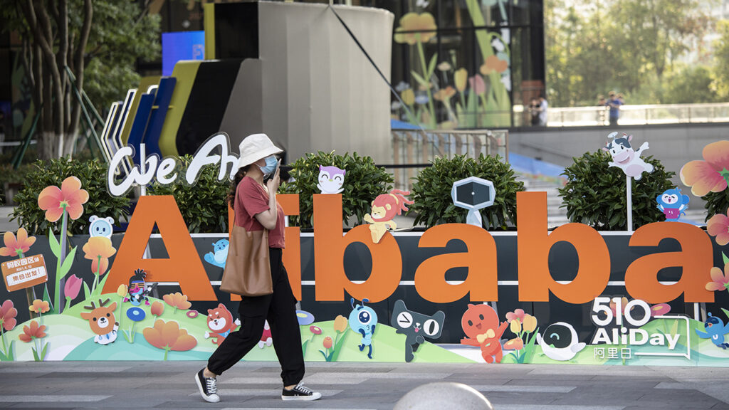 A person walks past a sign at the Alibaba Group Holding Ltd. headquarters in Hangzhou, China, on Saturday, May 8, 2021. Alibaba is scheduled to report